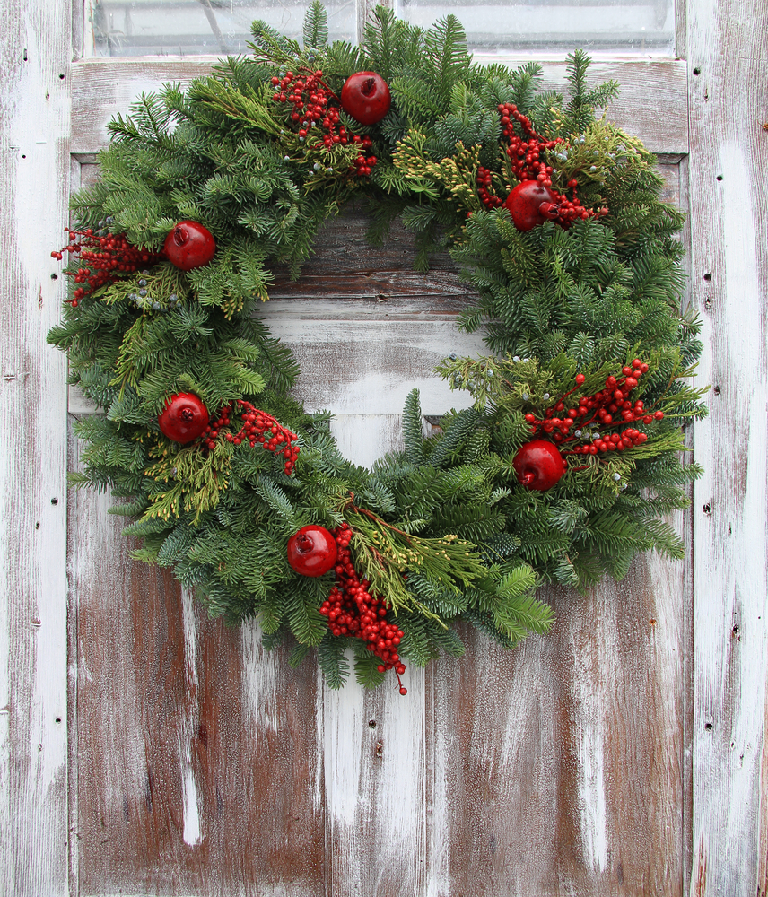 Christmas wreath on a rustic wooden front door.